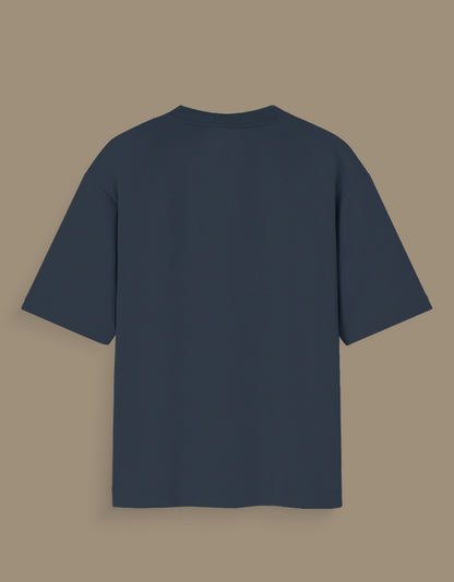Back view of a plain dark gray personalized oversized T-shirt India displayed on purple background