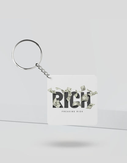 Square rich money keychain with the word RICH and flying dollar bills design