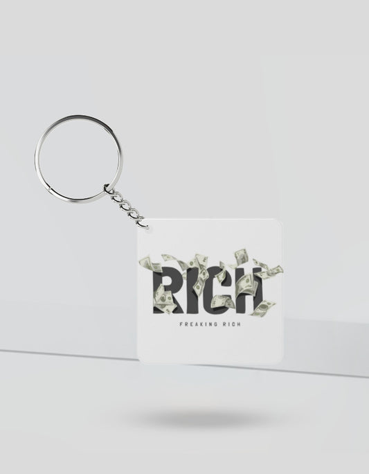 Square rich money keychain with the word RICH and flying dollar bills design